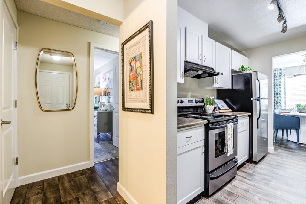 A kitchen with a black fridge and stove top oven.